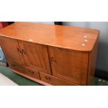 An Ercol light elm sideboard, three door cupboard over two long drawers.