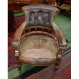 An early Victorian oak desk chair, leather scrolling button back,