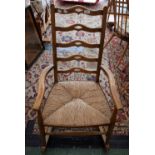An oak country rocking chair, shaped and pierced ladder back,