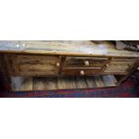 A rustic pine sideboard, plank top, two drawers, flanked by cupboards, turned supports,