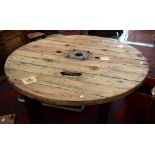 Industrial salvage - a large weathered pine cable drum table, circular top, H section girder legs.