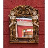 A decorative reproduction mirror by Alan Wells cherub design