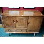 An Ercol elm sideboard, oversailing top, small cupboard over single drawer,