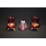 A pair of Victorian cranberry glass and floral printed candle stands;