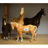 A large Beswick model of a Palomino horse, 30cm, printed mark; a similar in gloss brown,