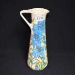 A contemporary Moorcroft jug, tube lined with blue flowers,