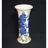A contemporary Moorcroft vase tube lined with trailing blue flowers,