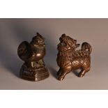 A Japanese hardwood netsuke, carved as a Komainu, signed, 5cm long; an Asian bronze opium weight,