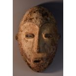 Tribal Art - a Dan or Gio mask, domed forehead, the scarified features with central ridge,