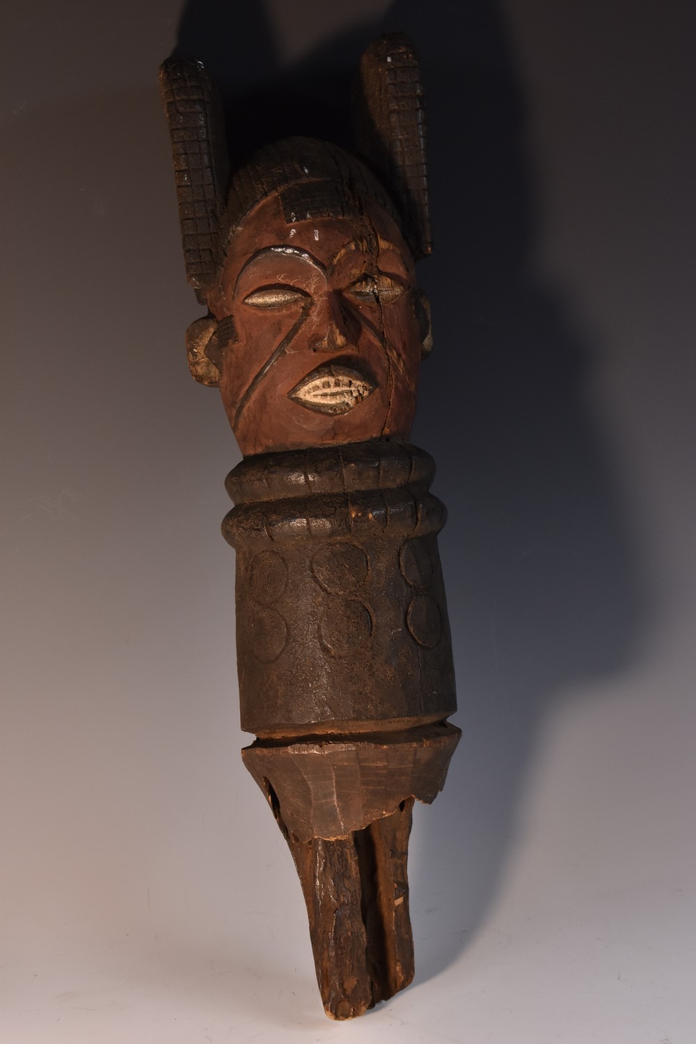 Tribal Art - an African figural house post totem, carved with a mask with scarified features,