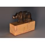 A Continental dark patinated miniature bronze, of a rhinoceros, rectangular marble base, 6.