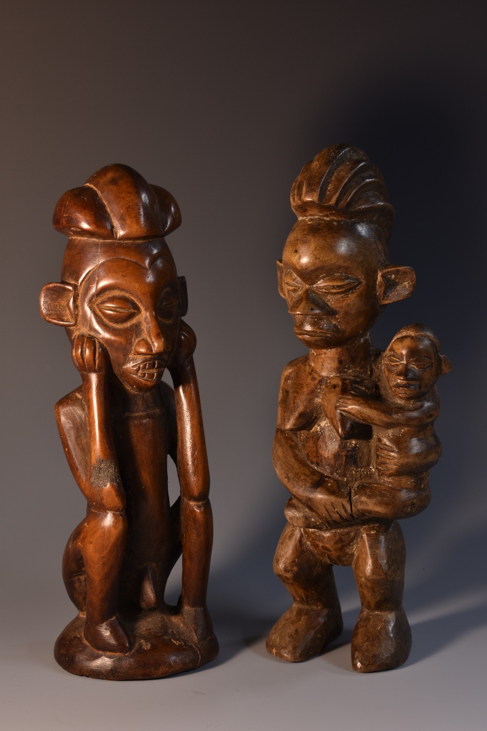 Tribal Art - a Yoruba figure, carved as a mother holding a child, 25cm high, Nigeria; another,