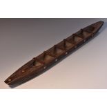 Tribal Art - a Maori model waka canoe, carved with stylised motifs and inlaid with abalone roundels,