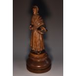 A Dutch/Flemish oak carving, of a lady carrying a laden basket, turned base, 31cm high,