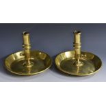 A pair of 18th century brass ejector chambersticks, tall cylindrical nozzles, dished drip pans,