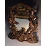 A Black Forest table mirror, boldly carved with hanging game and fruiting vine,
