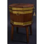 A George III brass bound mahogany octagonal cellaret, the hinged cover enclosing a zinc liner,