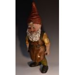 A large 19th century composition garden gnome, he stands dressed in a work apron,