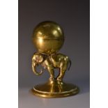 A late 19th century brass novelty inkwell, as an elephant supporting a ball, hinged cover,