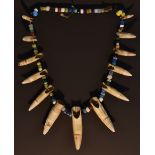 Tribal Art - a sabre teeth and bead necklace,