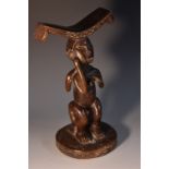 Tribal Art - an African figural headrest, the curved cresting with chequered ends,