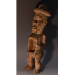 Tribal Art - a Nkysi fetish or power figure, standing, his arms flanking a niche at his waist,