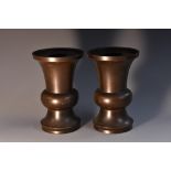 A pair of Japanese dark patinated bronze vases, of 'gu' shape, raised rims with detachable collars,