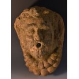 A 19th century terracotta spout head, modelled as a mask, 30cm long, c.