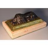 A large 19th century dark patinated and polished bronze desk weight, as a recumbent lion,