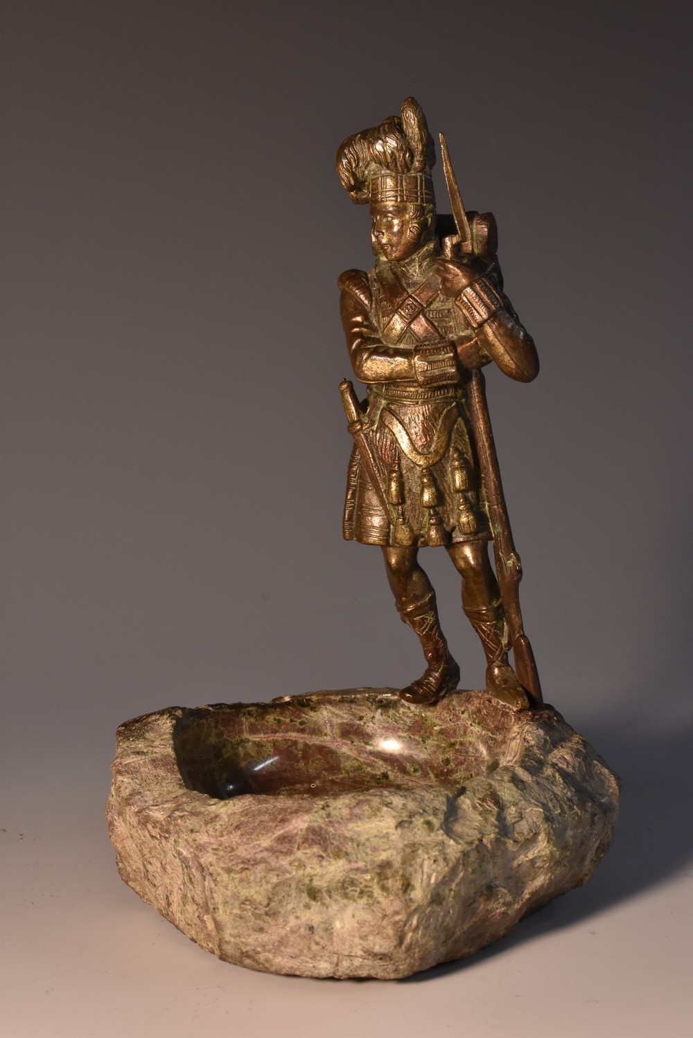 A 19th century bronzed figure, of a Highland soldier, he stands, in traditional uniform,