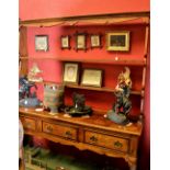 A country oak dresser, ogee cornice, shaped uprights and shelving to top, two long drawers,