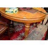 A late Victorian light oak wind out dining table, oval top, inverted baluster lobed legs,