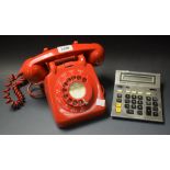 A red dial telephone adapted for current use;