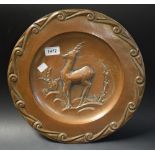 An Art Deco circular plainished copper plaque, the dished central field embossed with an ibex,