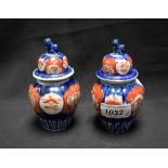 A pair of miniature Japanese Imari baluster vases and covers