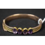 A silver gilt hinged bangle set with four faceted oval amethysts, unmarked,