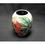 A contemporary Moorcroft ovoid vase, decorated with tropical orchids and large leaves,