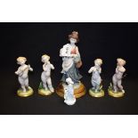 A set of four Capodimonte putti musicians; another blanc de chine putti with hare;