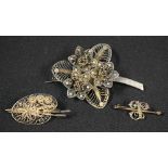 A silver filigree artist's easel brooch; another as flowers;