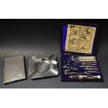 A set of drawing instruments; an Art Deco cigarette case; an advertising ashtray,