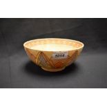A Charlotte Rhead bowl, tube lined with chevron leaves, in tones of orange, yellow and blue,