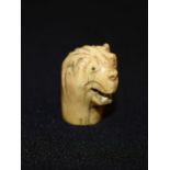 An 18th century bone pommel, of small proportions, carved as the head of a bear,