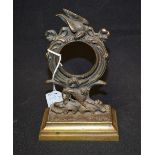 A post-Regency dark patinated bronze pocket watch stand, circular aperture crested by an eagle,