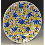 A Dutch tin glazed charger, decorated in yellow and blue with stylised foliage,