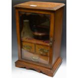 A late 19th century oak smoker's cabinet, with glazed door, the interior with pipe rack,