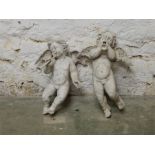 A pair of winged stone-effect resin flying cherubs / putti. Modern