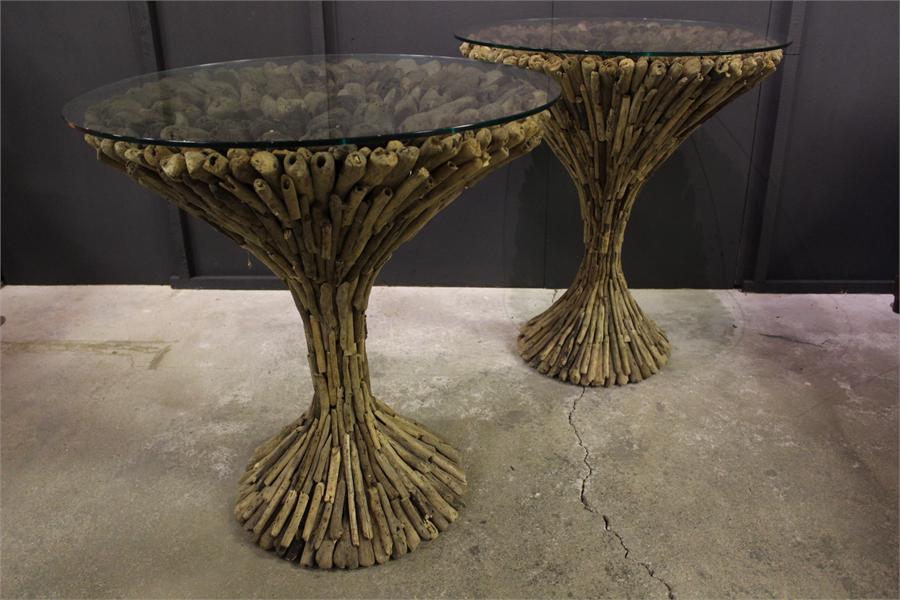 A pair of driftwood round glass top display tables. glass tops not attached.