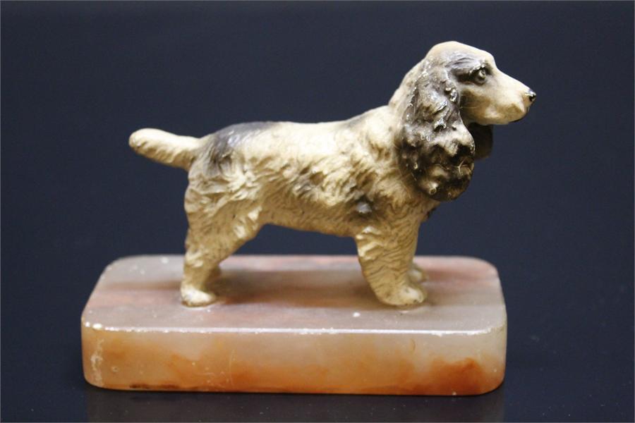 A cold painted metal spaniel dog on marble mount.