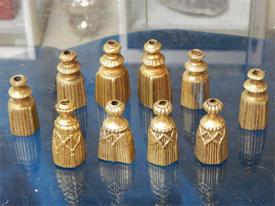 Ten gold painted alloy curtain pulls in the form of a bell.