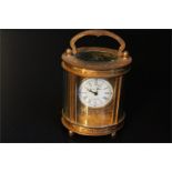 miniature oval brass carriage clock with chased floral decoration, dial signed Elliott and son